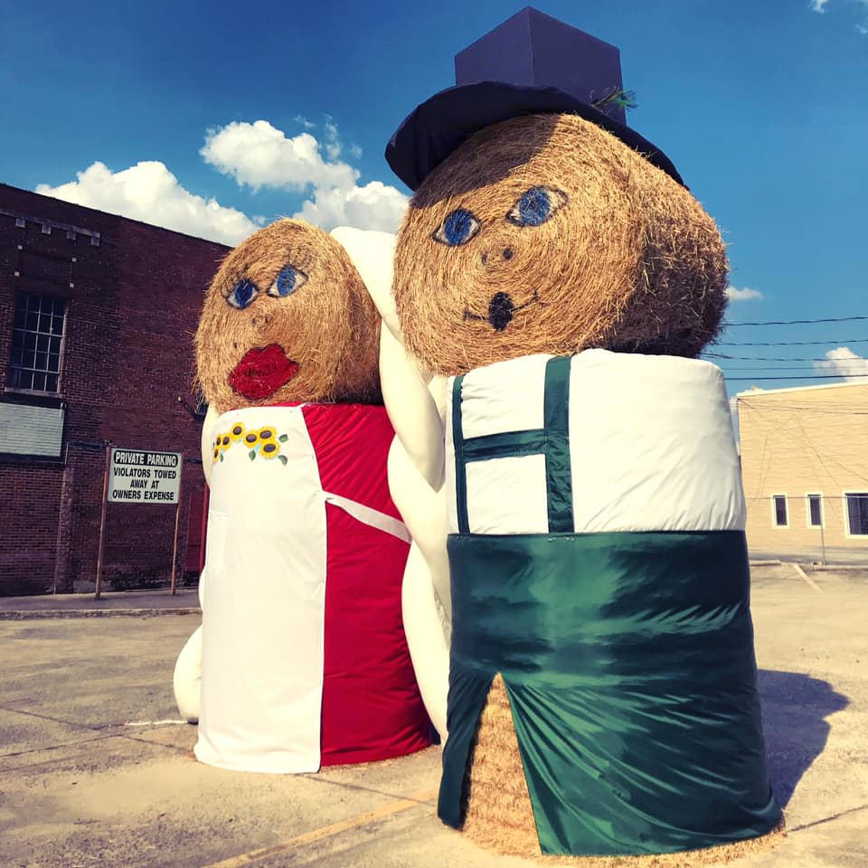 Two stacks of haybales dressed and painted to look like a farm couple - oktoberfest