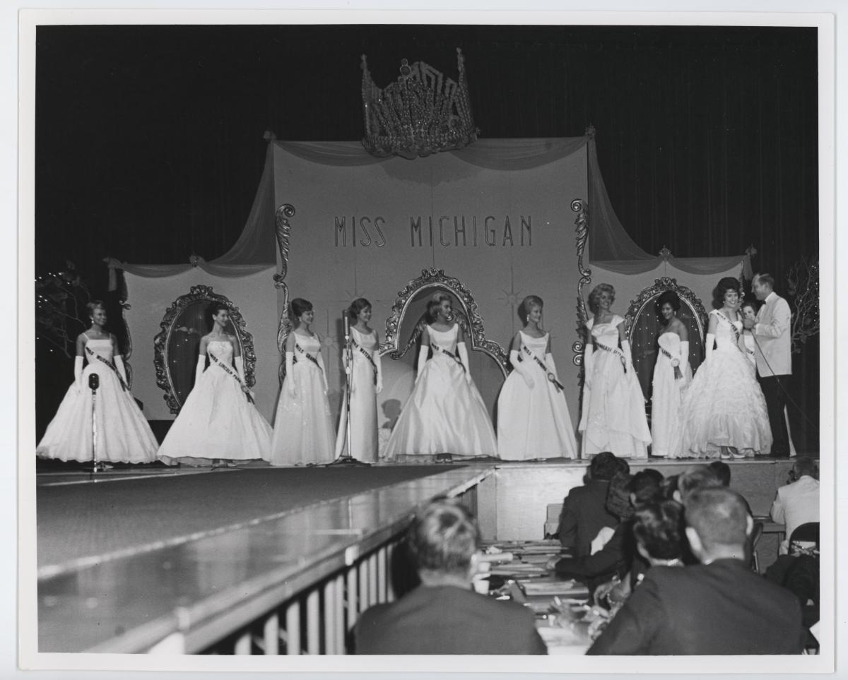 black and white photo of 9 miss michigan contestants on stage, perhaps 1960s?