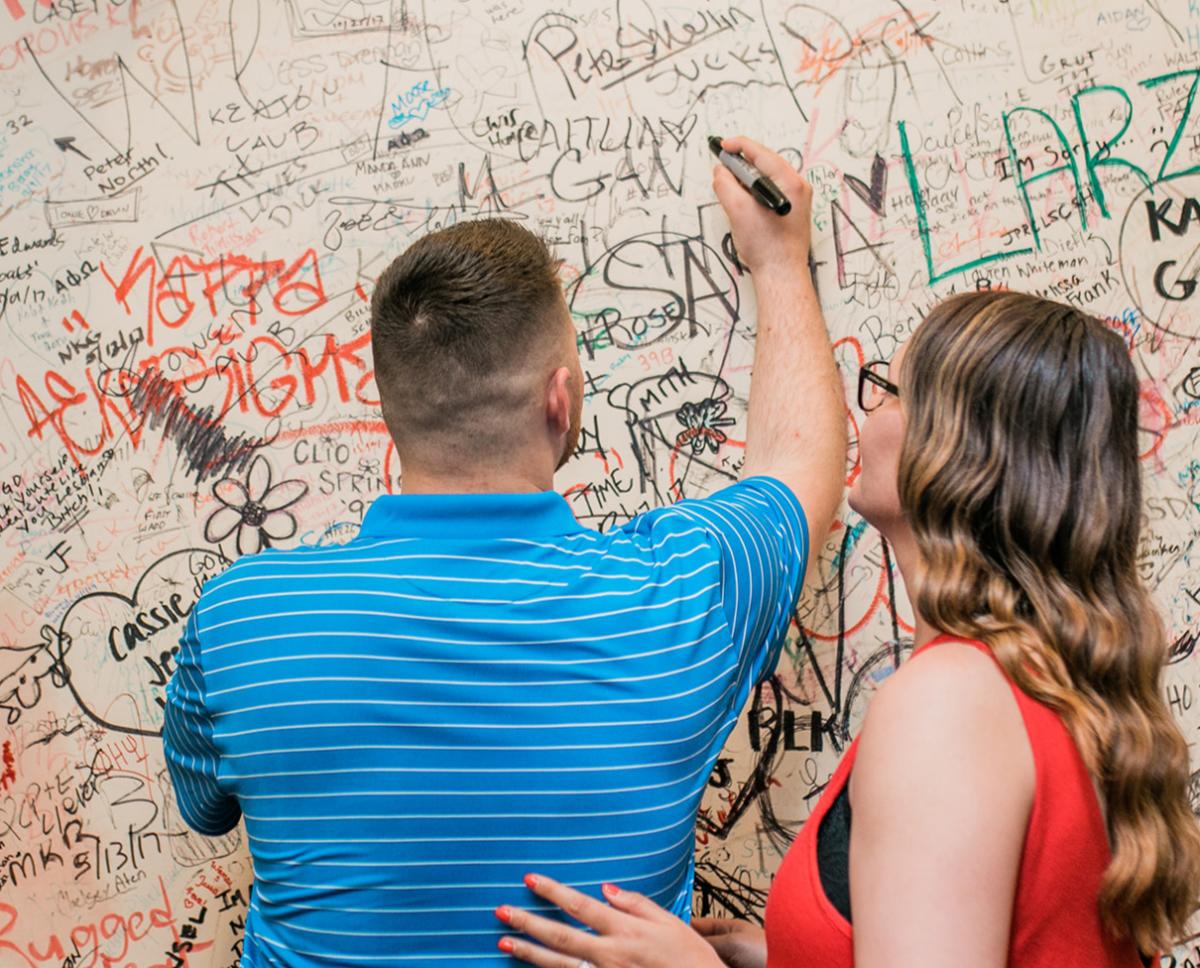 Couple Signing Kelly's Wall