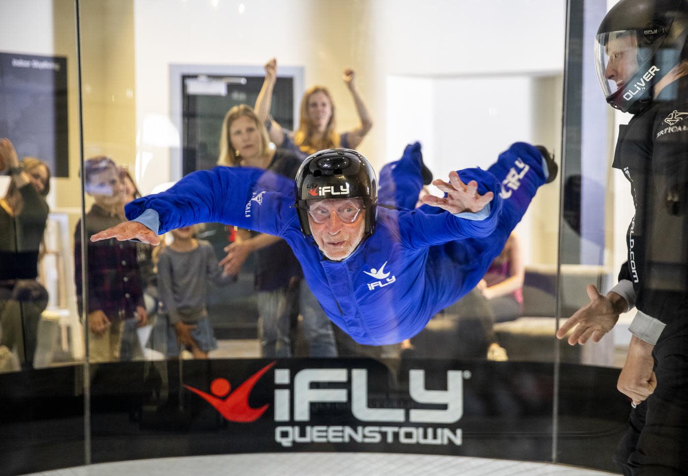 Mature man indoor skydiving in blue suit