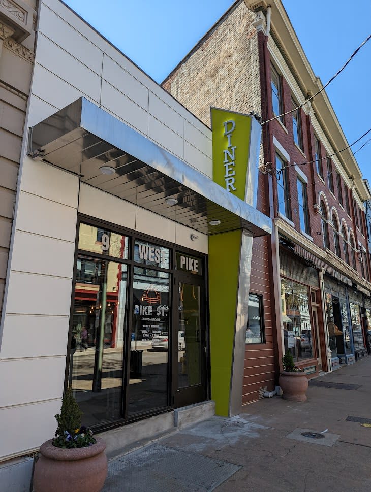 Image is of the outside, front facade of Pike Street cluding a sign that says "Diner".