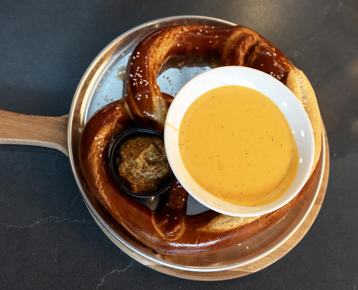 large soft pretzel and and side of beer cheese on a plate