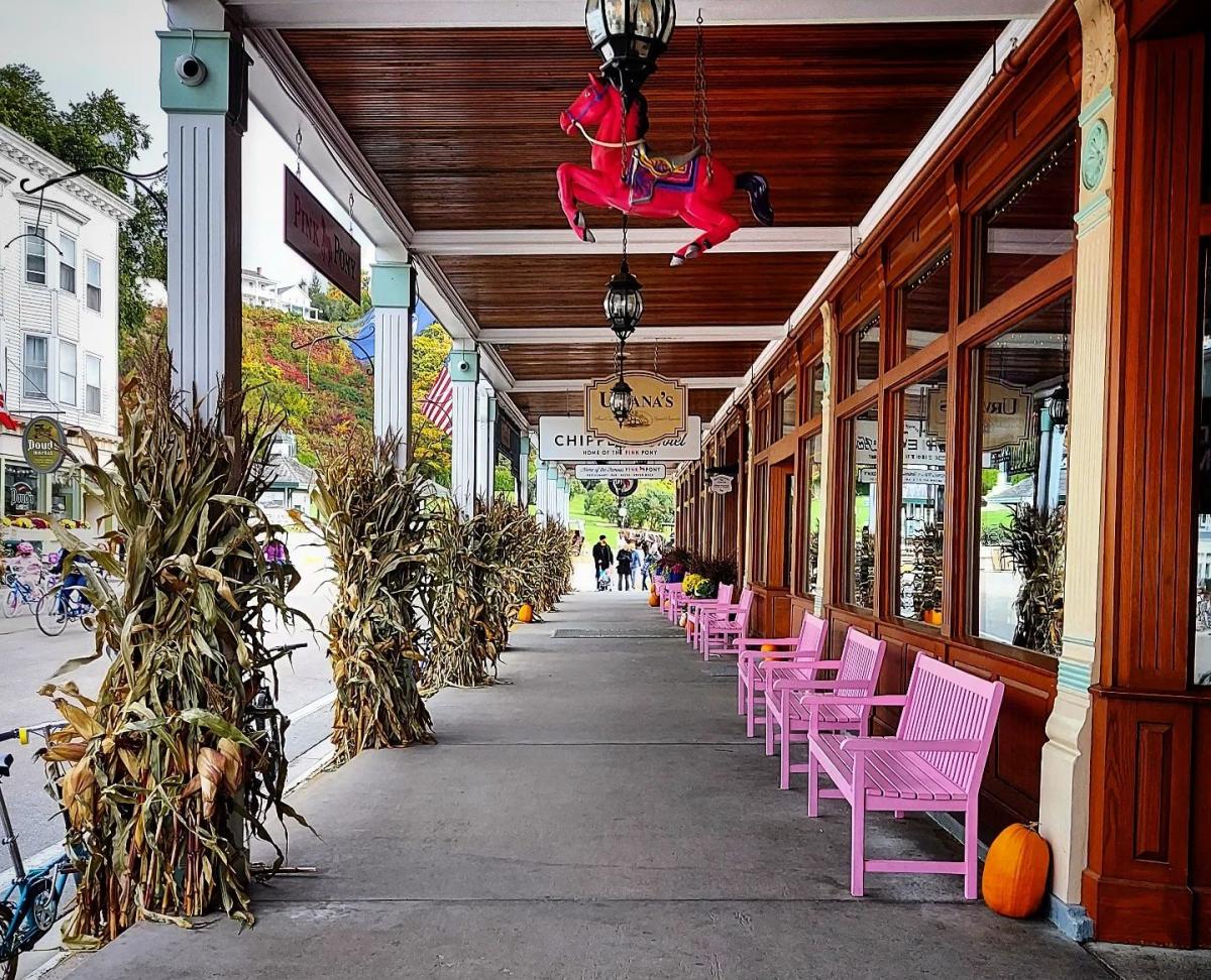 Pumpkins and corn stalks line the downtown streetscape of Mackinac Island in fall