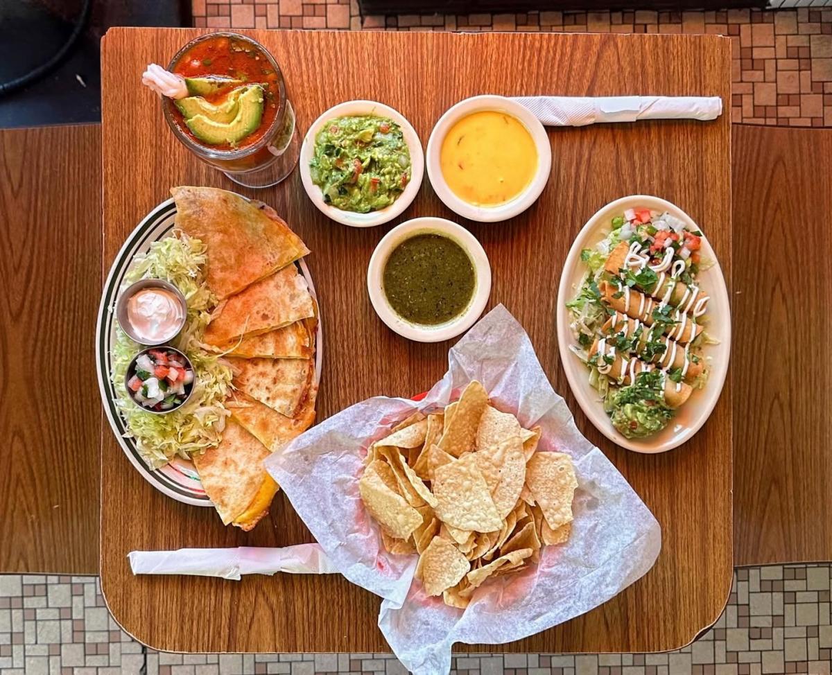 Overhead image of a table filled with entrees, chips and salsas at Cisco's.