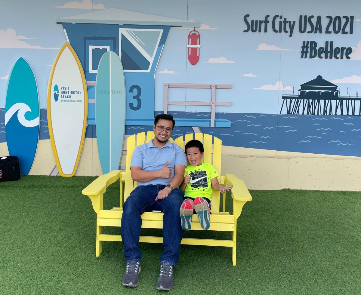 Father and son sitting on a yellow bench at Bella Terra.
