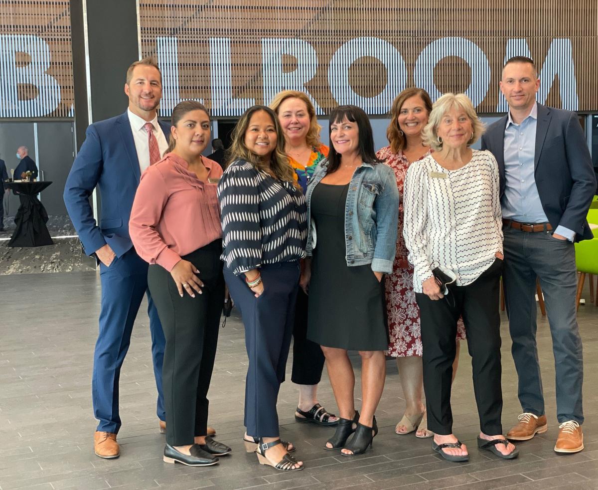 visit sacramento sales team standing in the ballroom of the convention center