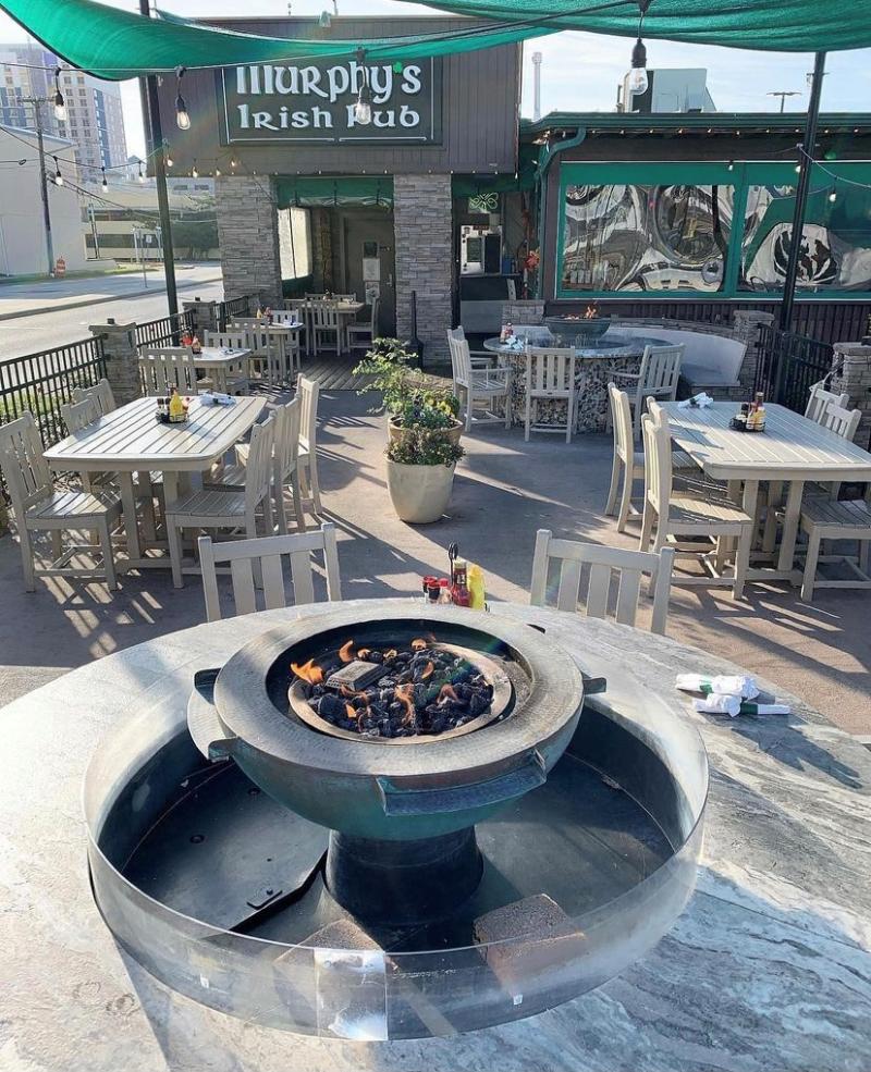 outdoor pub area with table top firepit featured in a table