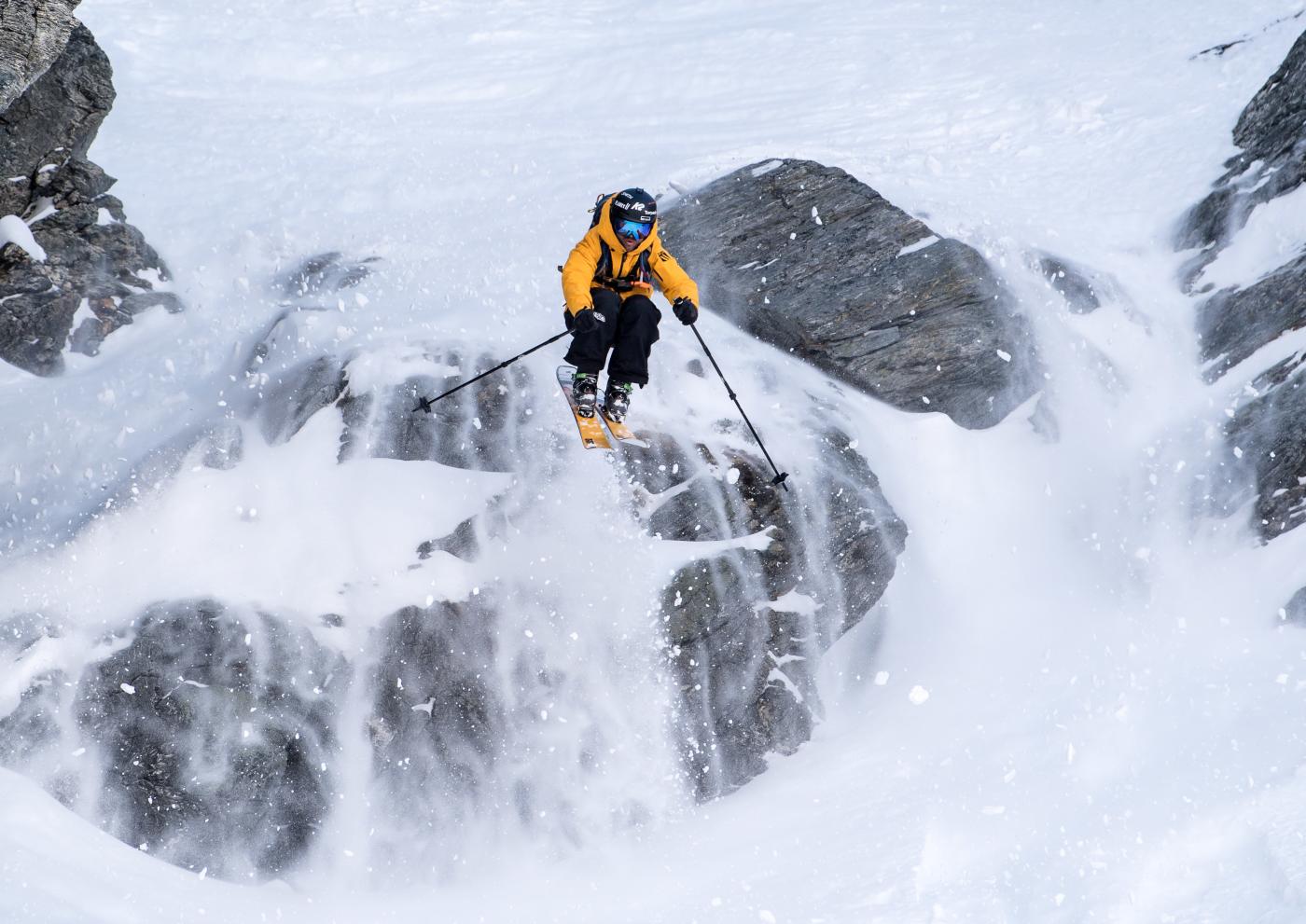 Freeskier Pete Oswald skiing down a rocky mountain face