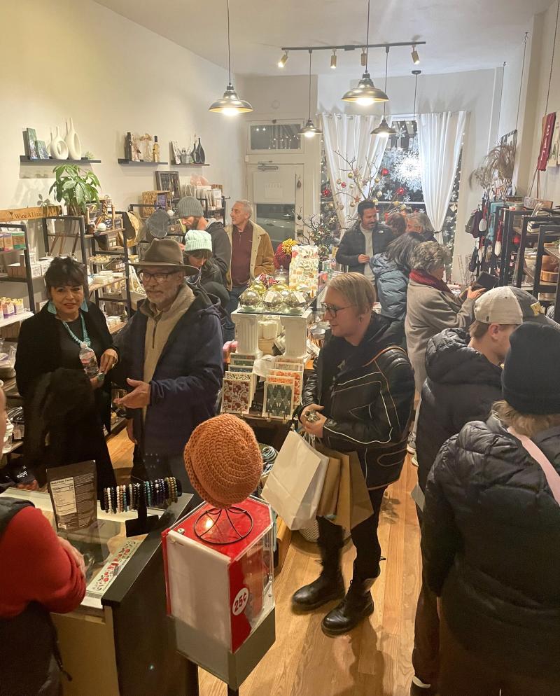 A view of the interior of What In Store - Gift Shop. There are a handful of customers shopping.