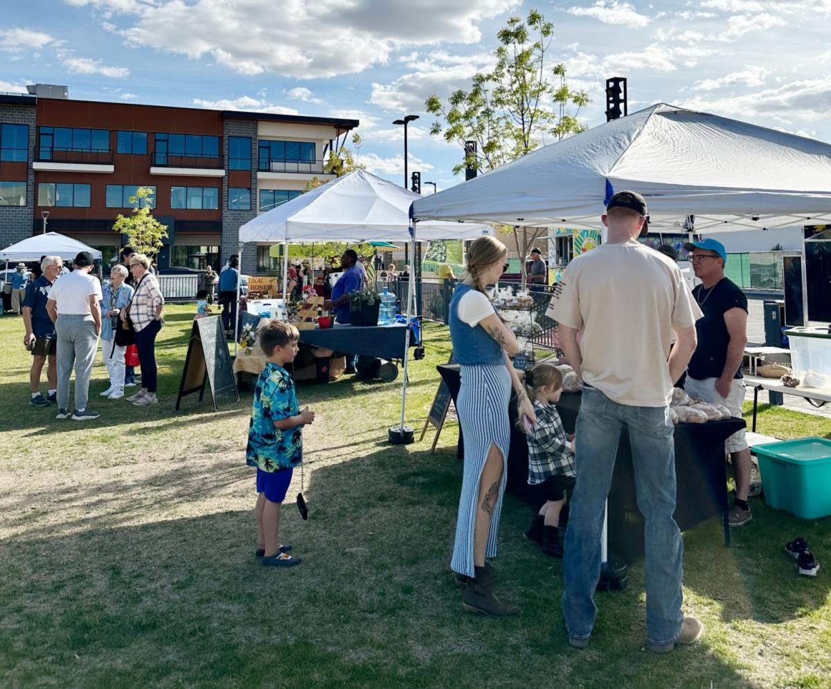 An image of some people shopping vendors at the Winrock Park Market.