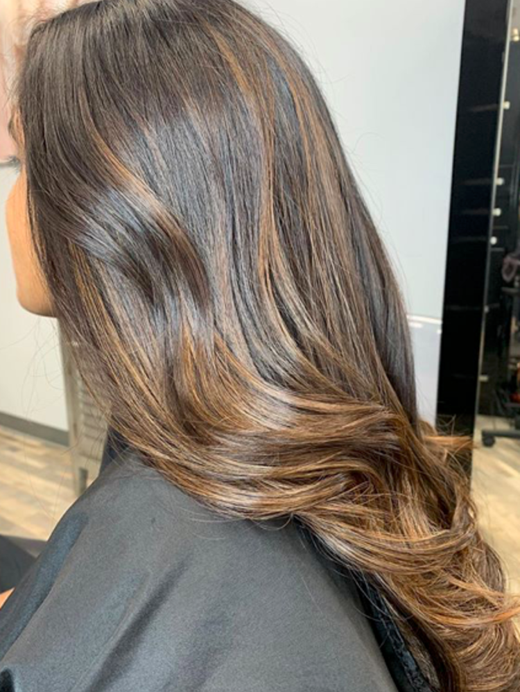 A woman poses with a new brunette hairdo