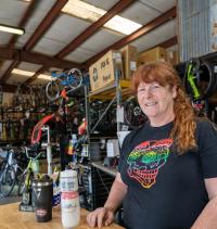 Kate Rockett smiling at the camera with bikes in the background.