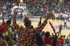 View of fans from behind as they cheer in the stands at the Atlanta Dream game.