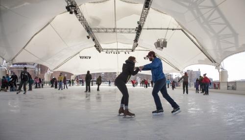 a man and a woman ice skating at the RiverScape ice rink