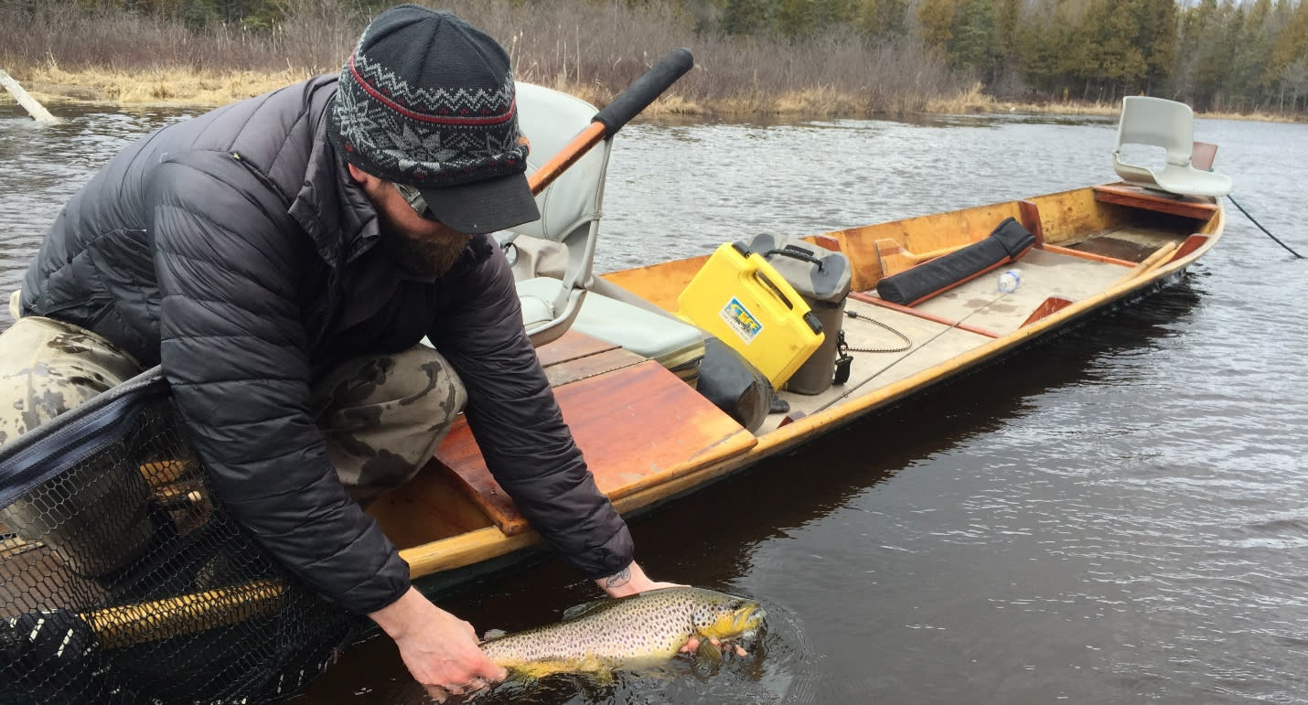 Fly fishing from a traditional AuSable riverboat