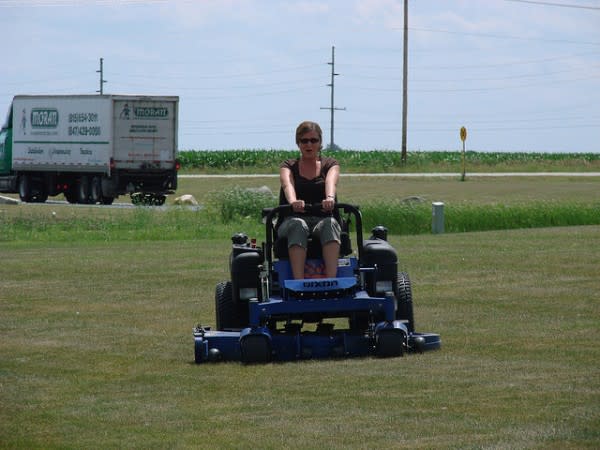 Woman driving a riding lawn mower