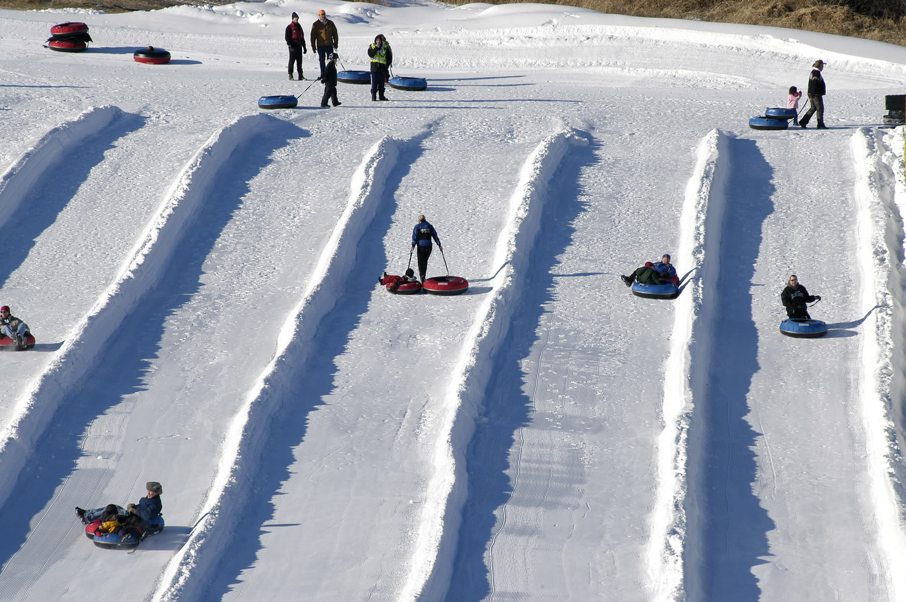 people tubing down large hill