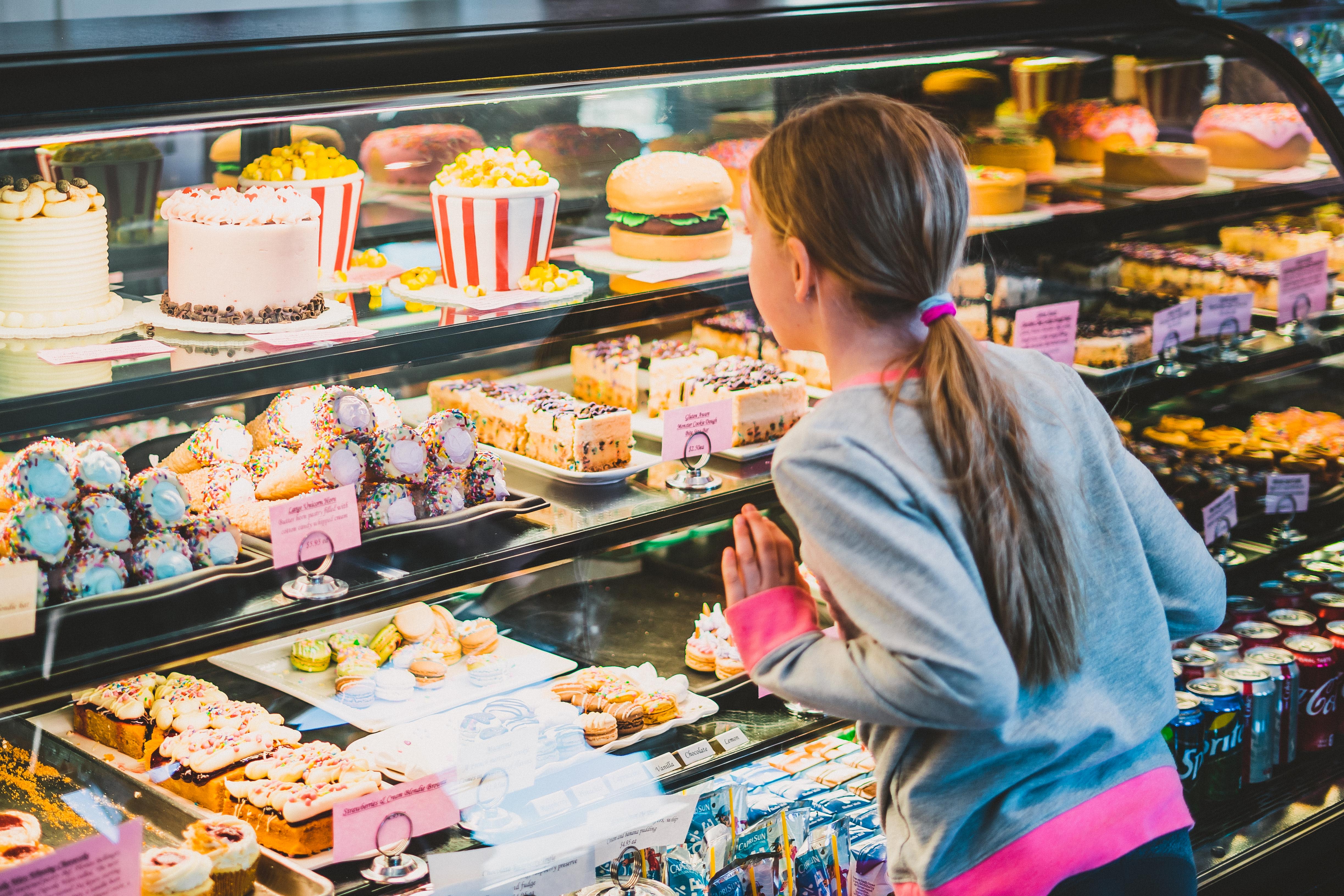 Little girl looking at desserts