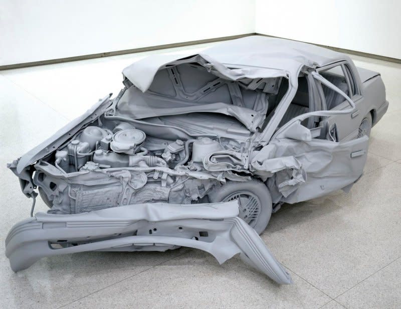 An all-gray sculpture depicting a wrecked car at the Walker Art Center