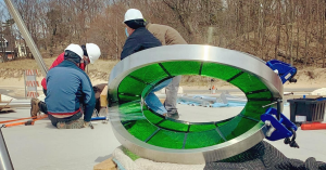 Workers installing the sculpture of steel and green glass