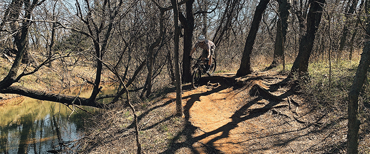 A man mountain biking on Bluff Creek Trail