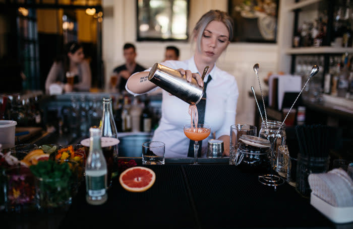 Woman pouring drink at bar