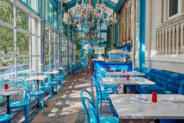Ocho restaurant interior with blue chairs and beautiful chandelier.