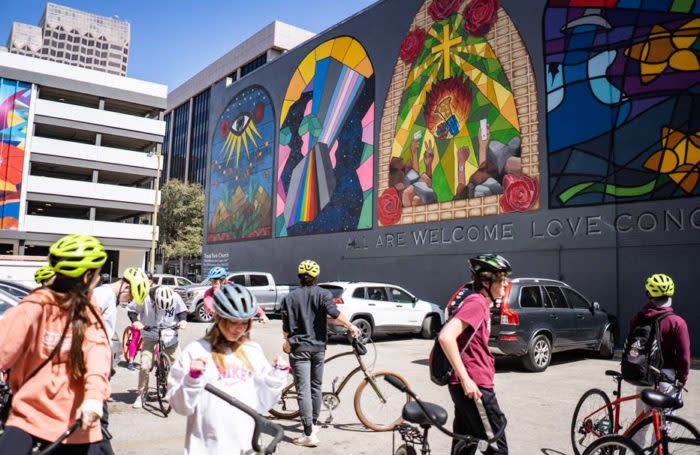 Visitors on bikes exploring murals.