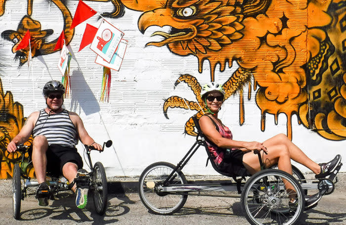 Two cyclists in front of Mural