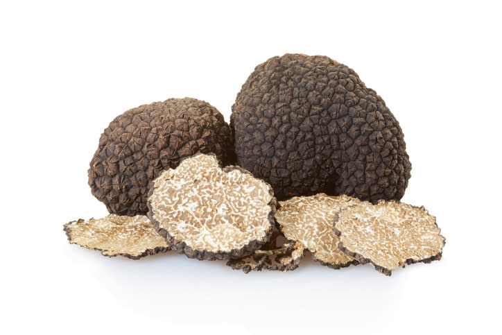 Black truffles group and slices on white