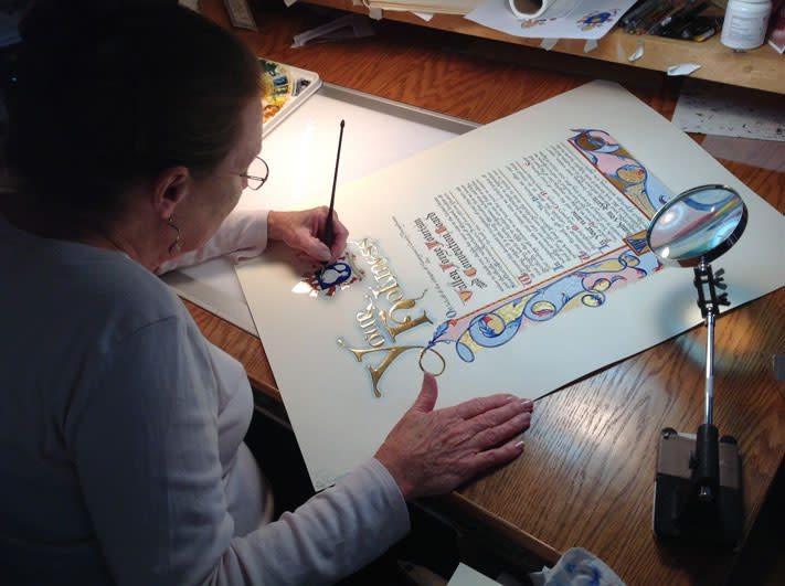 Rosemary Buczek works on the scroll that will be delivered to Pope Francis.