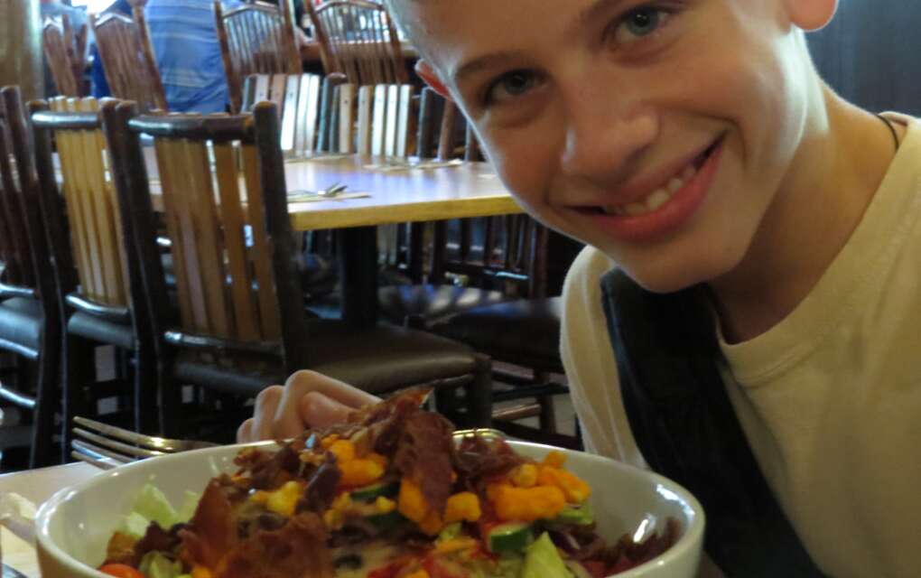 Tina M. Brown's 12-year-old son, Logan, prepares to dig into an allergy friendly salad at Trail's End.