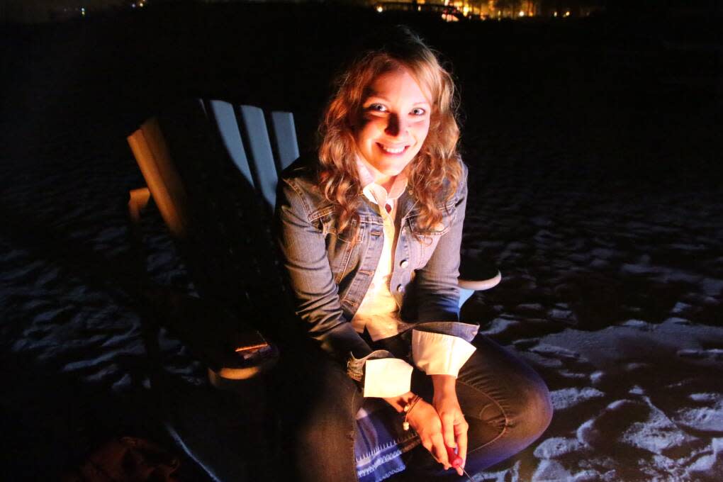 Rachelle toasting a marshmallow on the beach in Amelia Island during The Ritz-Carlton's Couples Fire On The Dunes.