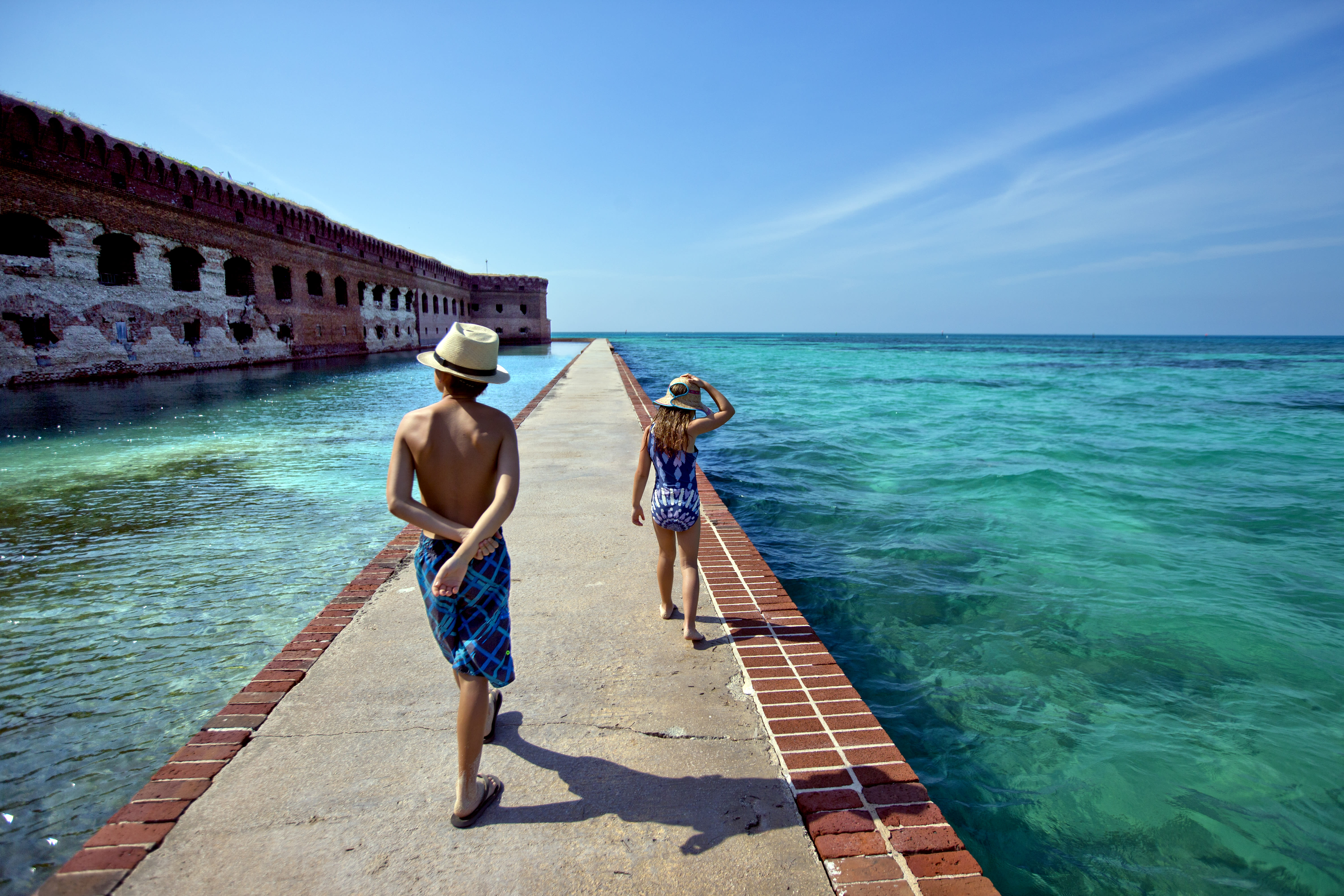 Two children walking down a path surrounded by water at Fort Jefferson in Dry Tortugas National Park