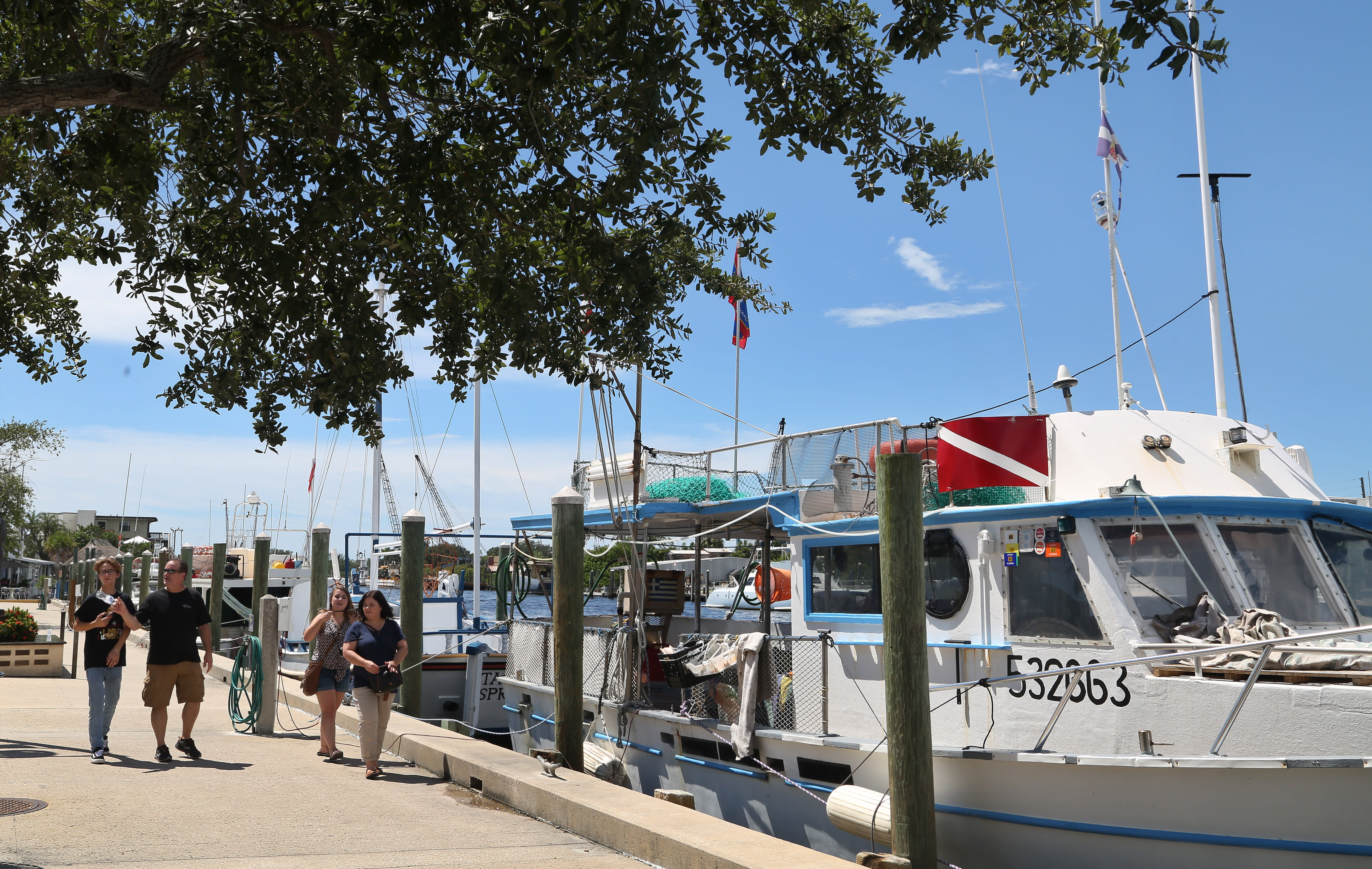 Visitors walk along the historic Tarpon Springs Sponge Docks on the Anclote River and Dodecanese Boulevard. Working sponge boats harvest sponges from the Gulf of Mexico which are sold around the world. 