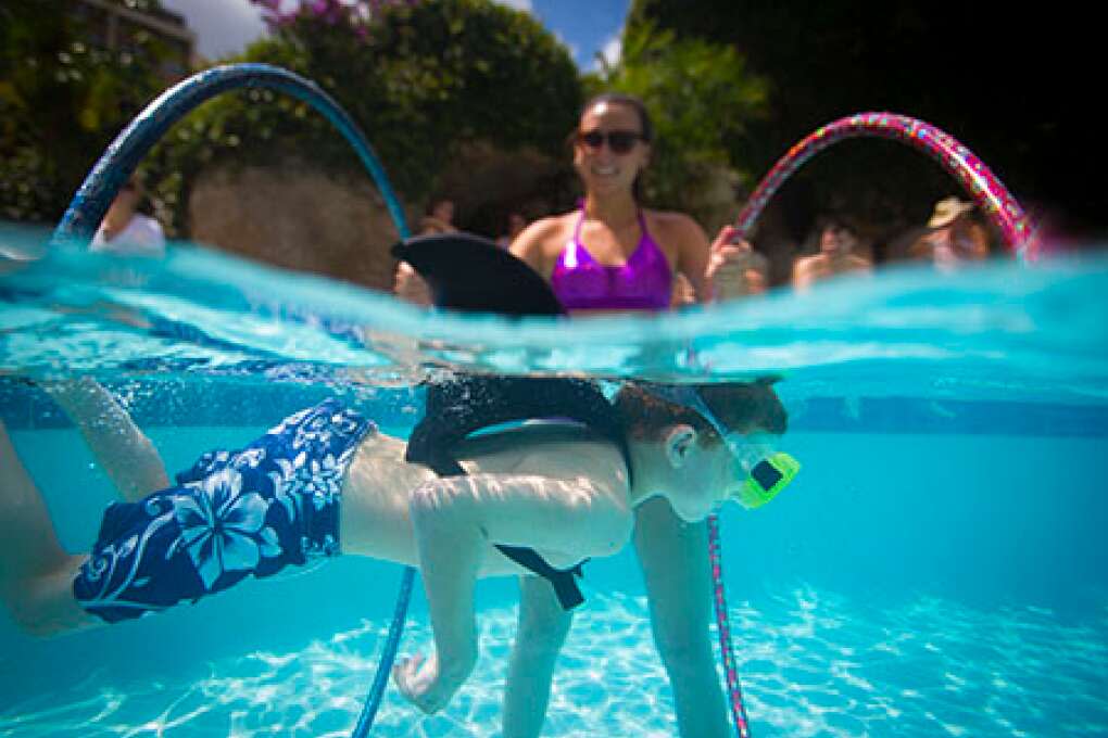 A young shark swims through hula hoops during The Mermaid Academy at the Hyatt Regency Grand Cypress in Orlando.