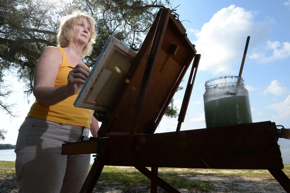 Helen Ballance, director of the Beach Art Group, paints air paints at Under the Oaks Park in Parker