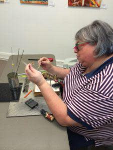 Glass artist, Linda, creating hand crafted beads at Le Originals