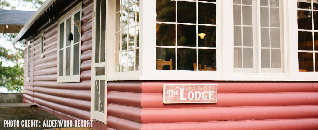 Photo of Alderwood Resort, a modern log cabin with large windows and a sign that says "The Lodge" 
