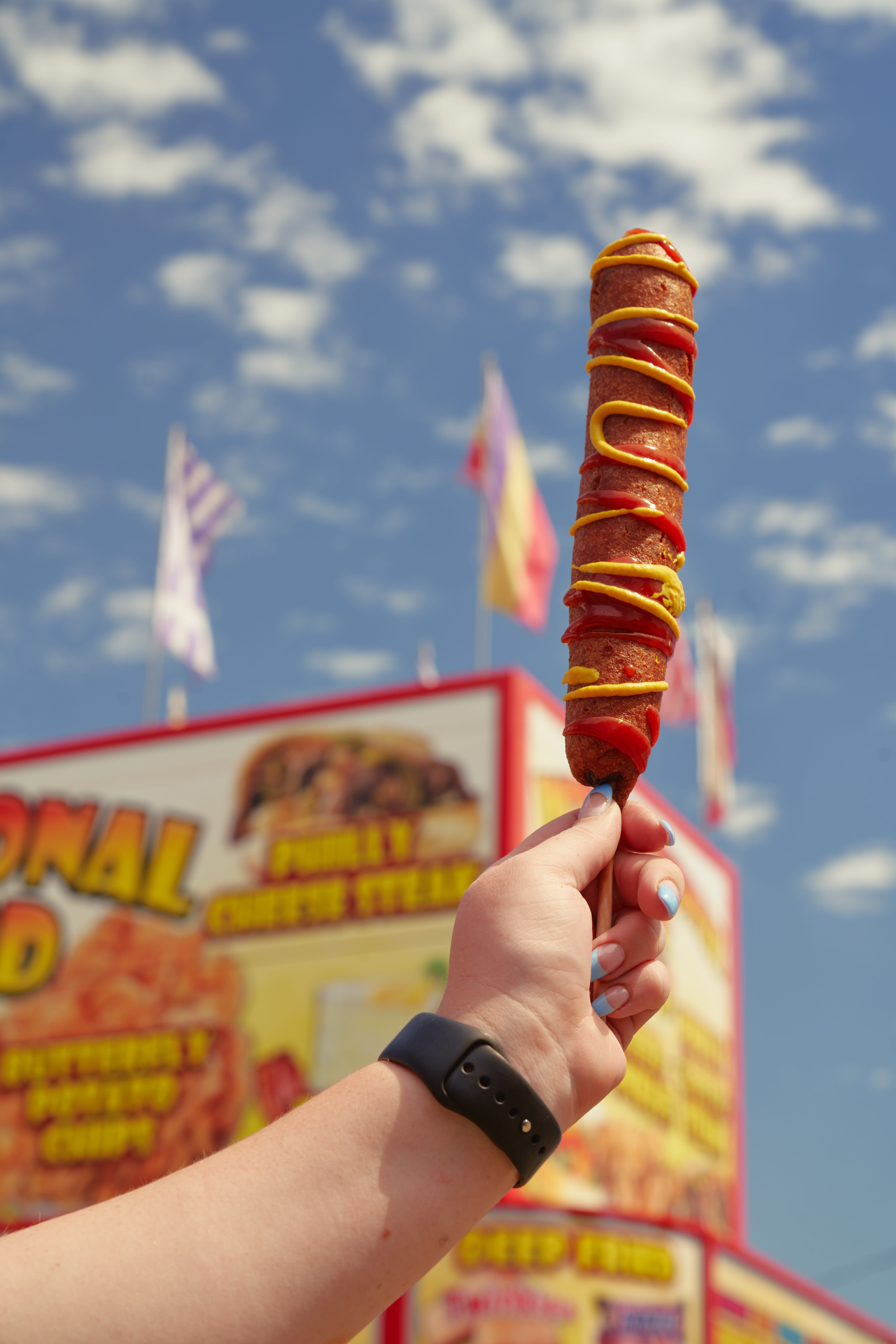 women holding a corndog in the air at the Wyoming State Fair.