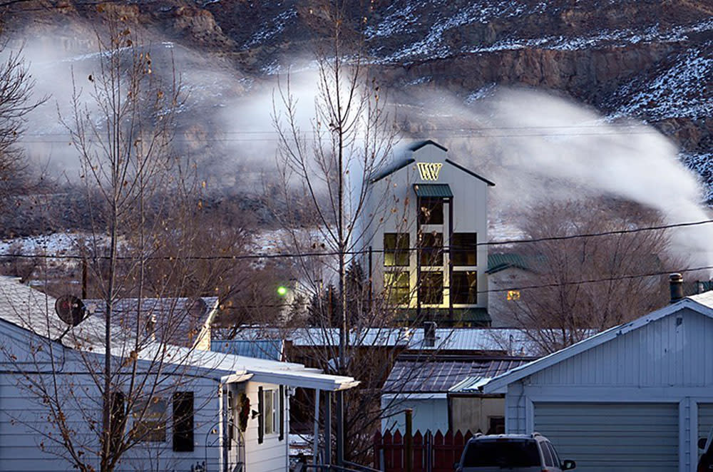 Houses in foreground with Wyoming Whiskey distillery behind them with mountains in the background.