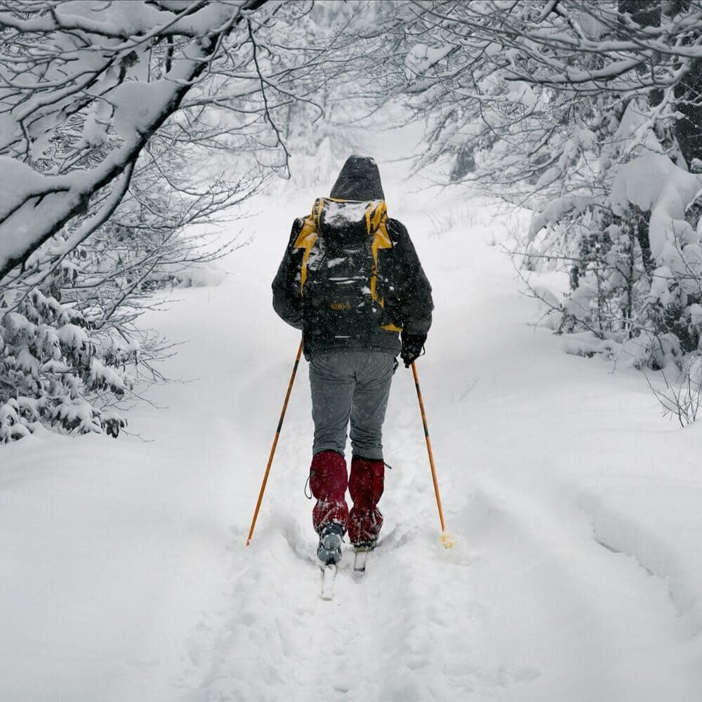 A person snowshoeing through a trail at Grand Teton National Park during the winter