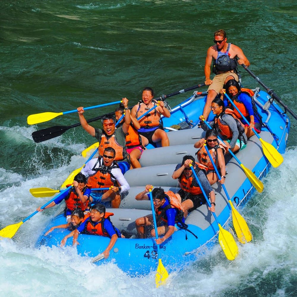 Raft with rafters paddling through rapids in Jackson Wyoming