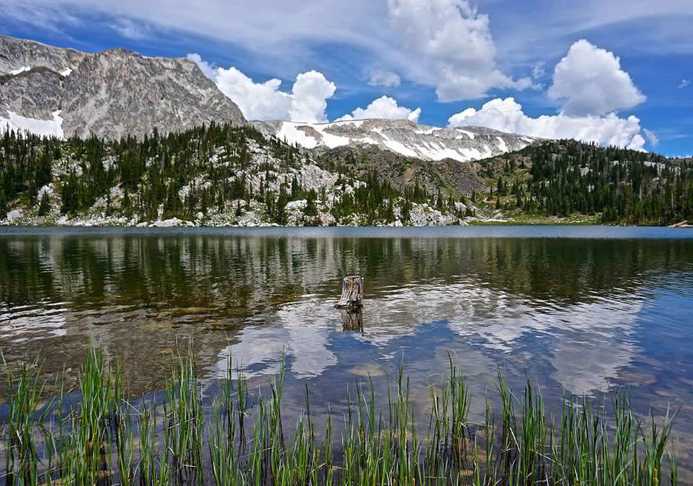 Lake with a mirror reflection of the mountains in the background.