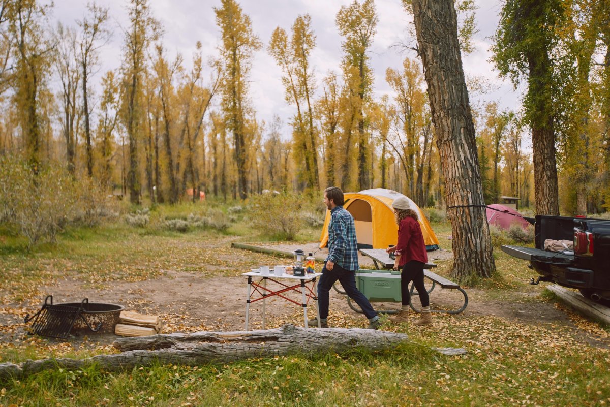 A young couple unloading their truck, setting up their tent camp site in Teton County
