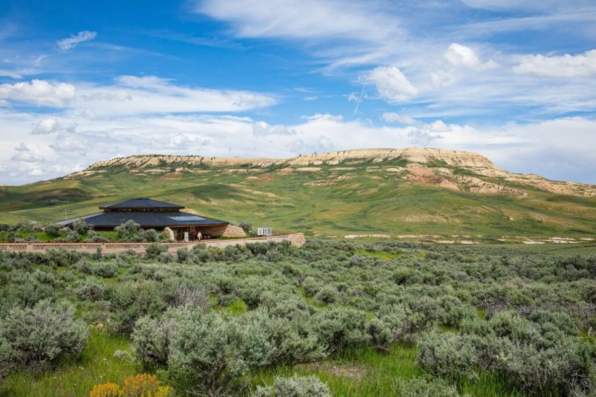 A sprawling view of the sagebrush desert, visitor center and distance rock formations at Fossil Butte National Monument.