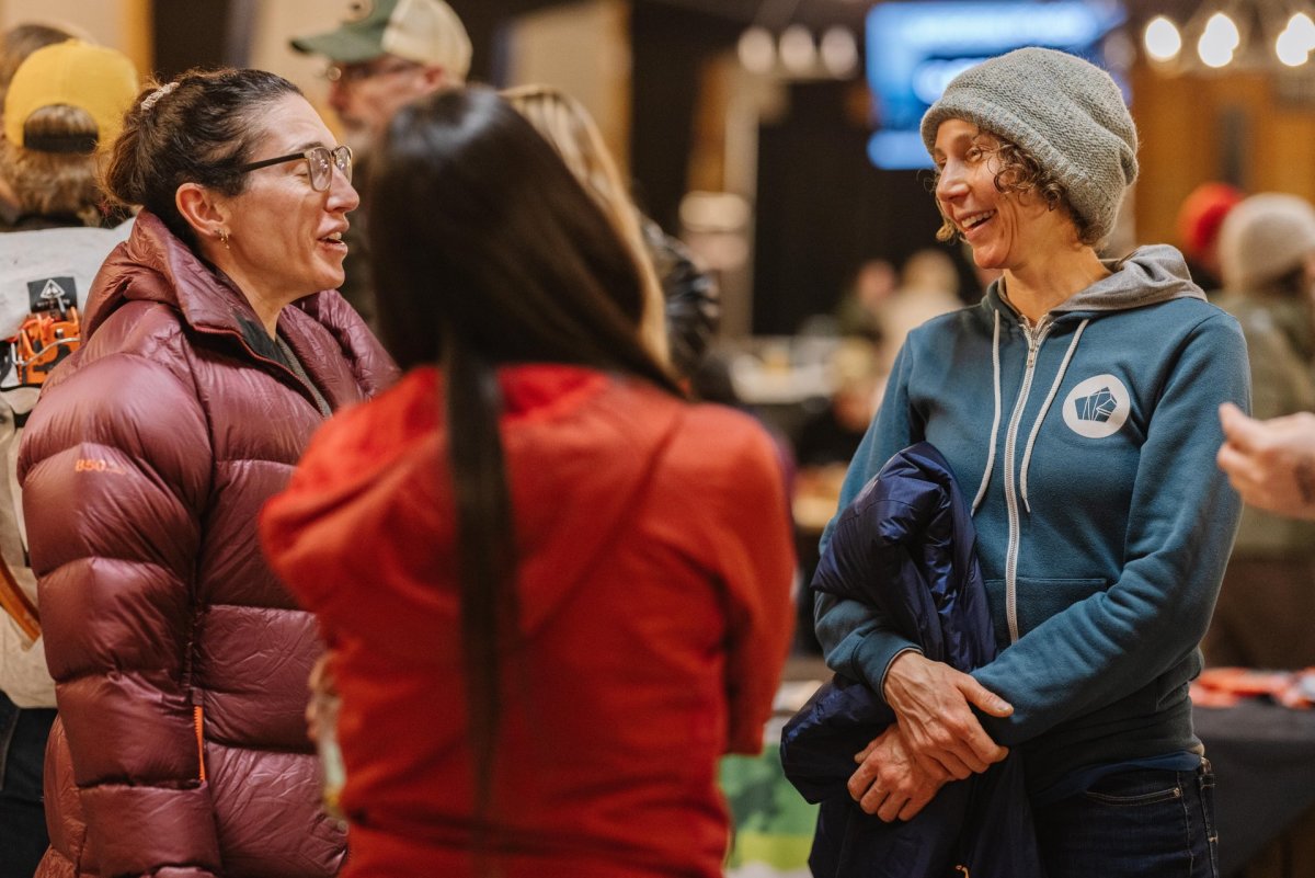 Three ladies talking wearing multiple layers of clothes.