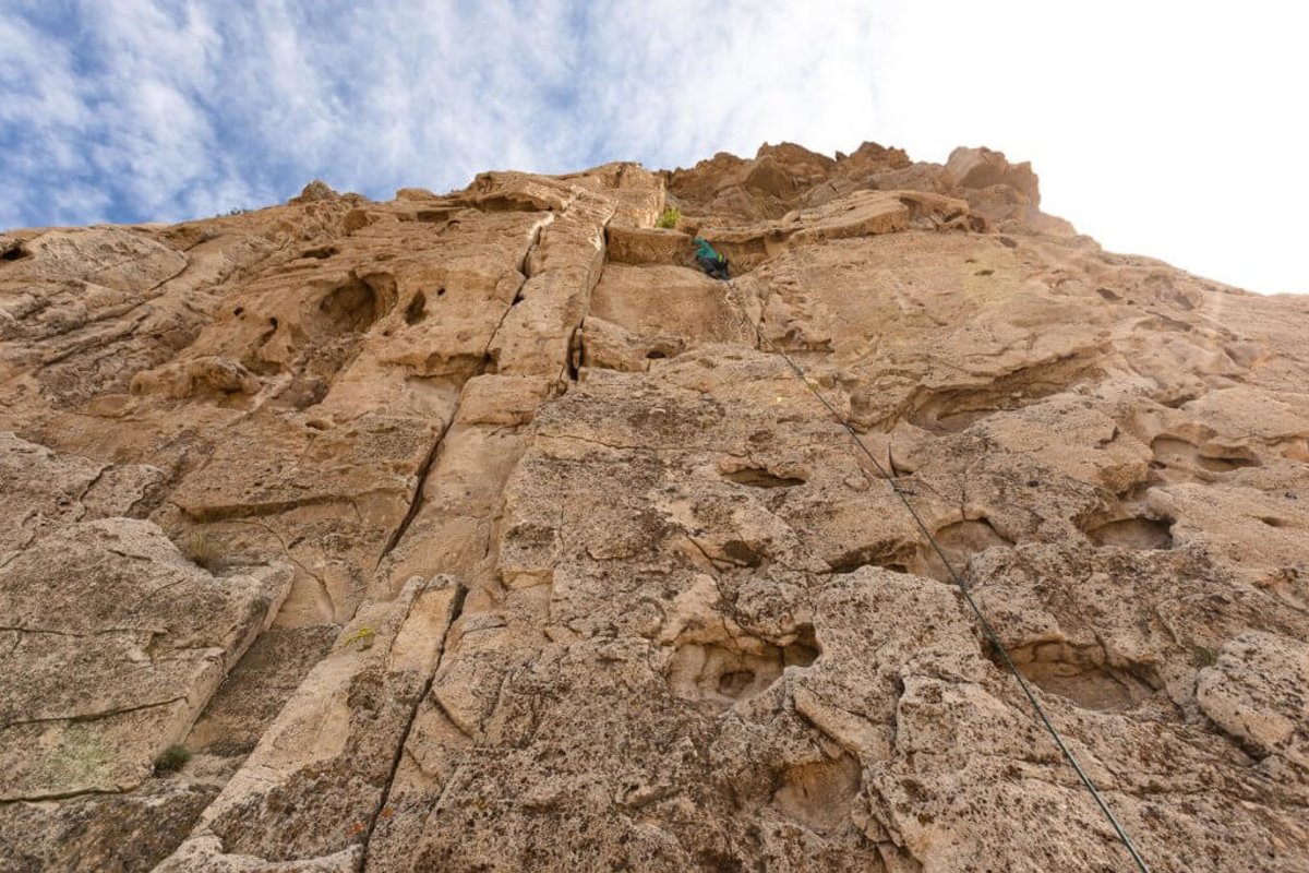 Climber high up on rock face at Cody Bridge Bands in Wyoming