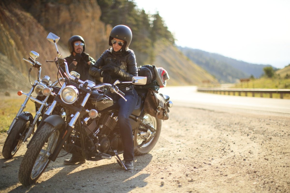 Couple on side of a scenic byway on motorcycles, enjoying the views near Buffalo, Wyoming.