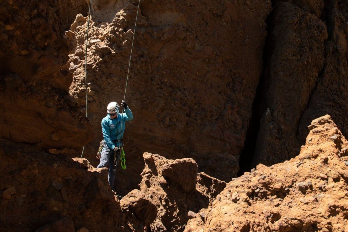 Person belaying a rock climber at Cody Towers climbing area in Wyoming